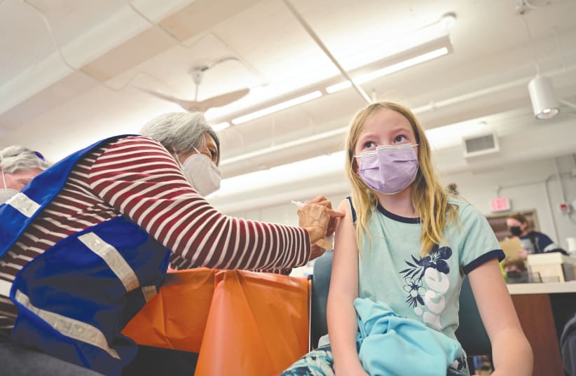 A YOUNG GIRL receives a dose of the Pfizer-BioNTech COVID-19 vaccine in Louisville, Kentucky, earlier this week. Will we be seeing similar scenes in Israel soon? (photo credit: Jon Cherr/Reuters)