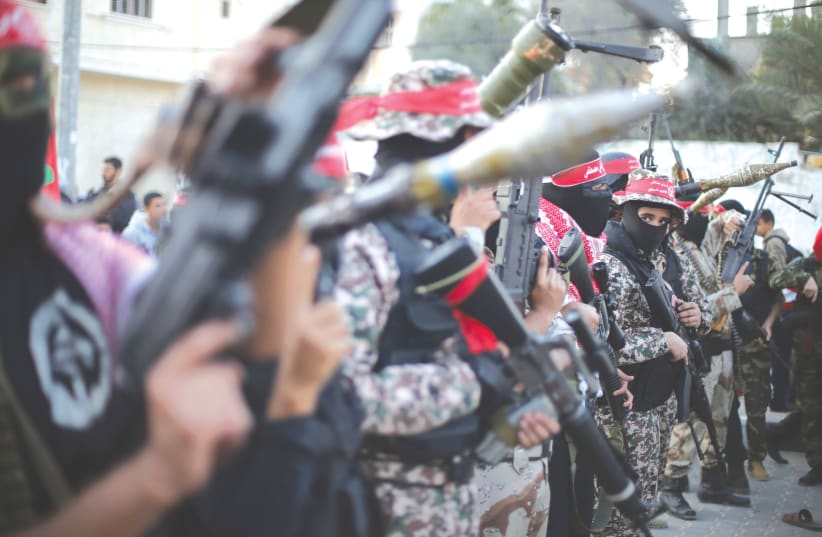 Members of the Popular Front for the Liberation of Palestine hold weapons in a military display in the Gaza Strip. (photo credit: IBRAHEEM ABU MUSTAFA/REUTERS)