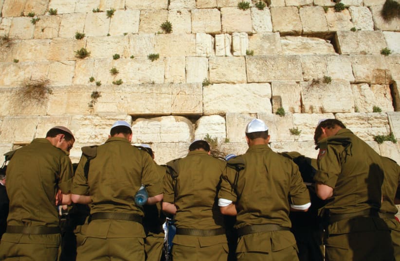  ISRAELI SOLDIERS pray at the Western Wall. Will they continue serving for such little pay? (photo credit: OLIVIER FITOUSSI/FLASH90)