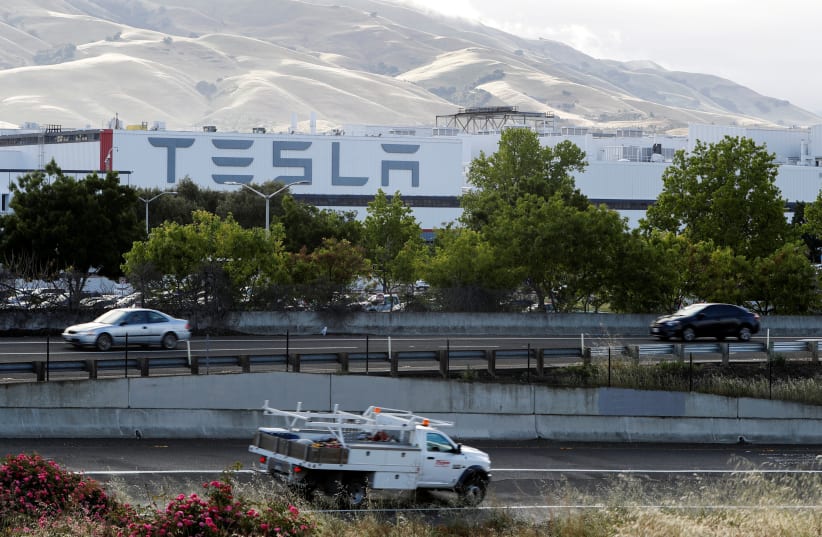  Motorists drive past Tesla's primary vehicle factory after CEO Elon Musk announced he was defying local officials' restrictions against the spread of the coronavirus disease (COVID-19) by reopening the plant in Fremont, California, US May 12, 2020.  (photo credit: REUTERS/STEPHEN LAM/FILE PHOTO)