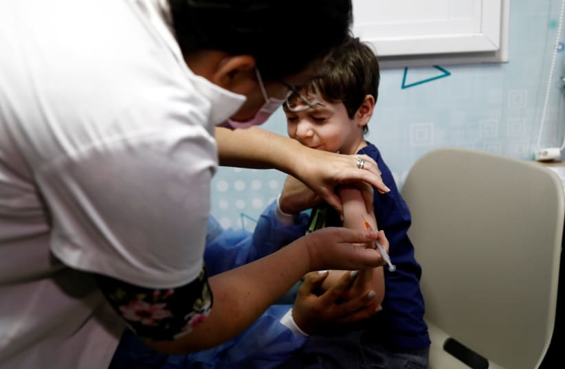  Itamar, 5-years-old, receives his first coronavirus disease (COVID-19) vaccination, after the country approved vaccinations for children aged 5-11, in Tel Aviv, Israel November 22, 2021.  (photo credit: REUTERS/CORINNA KERN)