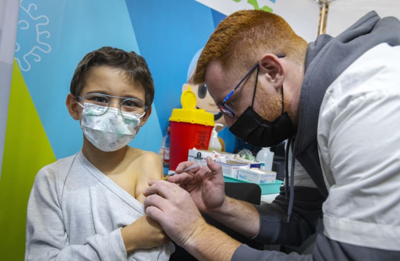  Children aged 5-11 receive their first first dose of Covid-19 vaccine, at a Clallit i vaccine center in Jerusalem on November 23, 2021.  (photo credit: OLIVIER FITOUSSI/FLASH90)