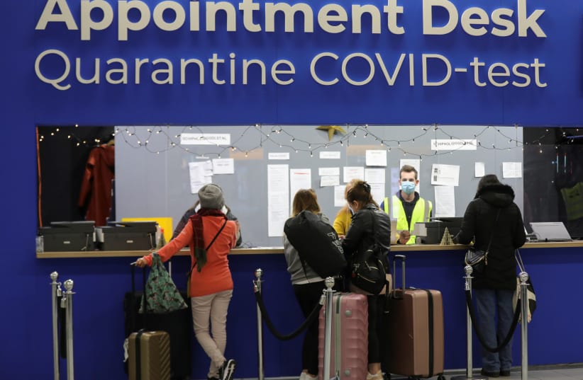  People wait in front of an "Appointment Desk" for quarantine and coronavirus disease (COVID-19) test appointments inside Schiphol Airport, after Dutch health authorities said that 61 people who arrived in Amsterdam on flights from South Africa tested positive for COVID-19, in Amsterdam, Netherlands (photo credit: REUTERS/EVA PLEVIER)