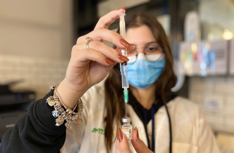 A Clalit health worker fills a syringe with the COVID-19 vaccine at Cinema City in Jerusalem. (photo credit: CLALIT HEALTH SERVICES)