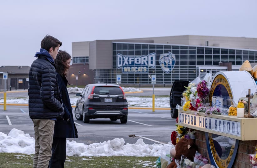 Students pay their respects at a memorial at Oxford High School a day after the year's deadliest U.S. school shooting which killed and injured several people, in Oxford, Michigan, US, December 1, 2021. (photo credit: REUTERS/SETH HERALD)