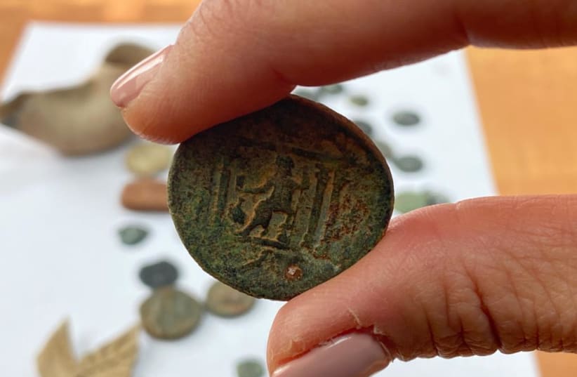  An ancient coin is seen among the artifacts seized from the home of an east Jerusalem resident on the last night of Hanukkah, on December 5, 2021. (photo credit: POLICE SPOKESPERSON'S UNIT)