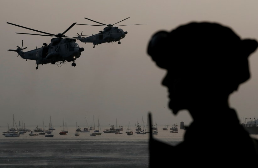  An Indian Navy marine commando watches Sea King Mk 42 ASW helicopters during a rehearsal ahead of Navy Day celebrations in Mumbai (photo credit: REUTERS)
