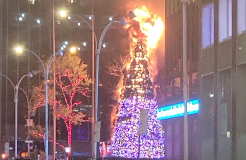 Christmas tree burns outside Fox News building in New York City, US, December 8, 2021 in this still image obtained from a social media video. (photo credit: TWITTER @RajeloNess/VIA REUTERS)