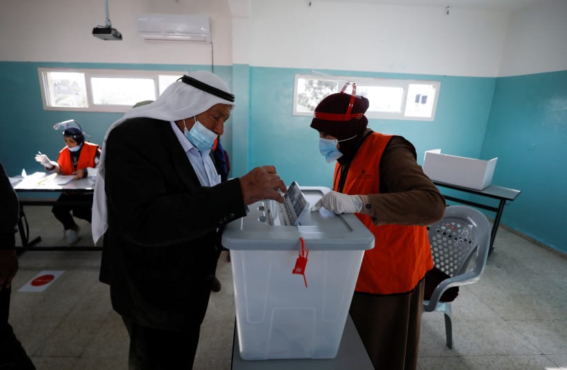  A Palestinian casts his ballot to vote in the municipal elections, near Jenin in the West Bank, December 11, 2021 (photo credit: REUTERS/MOHAMAD TOROKMAN)