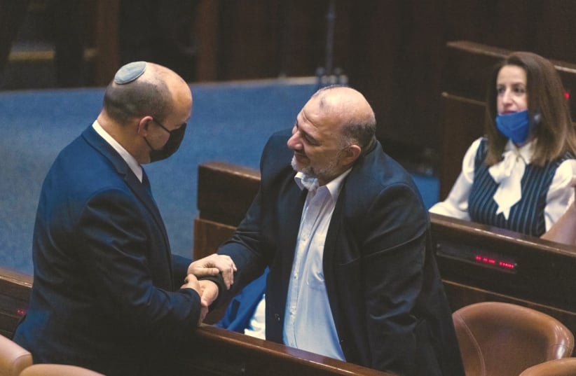  PRIME MINISTER Naftali Bennett shakes hands with MK Mansour Abbas in the Knesset. Large parts of the Jewish population do not recognize Israel’s Arabs as equal citizens. (photo credit: OLIVIER FITOUSSI/FLASH90)