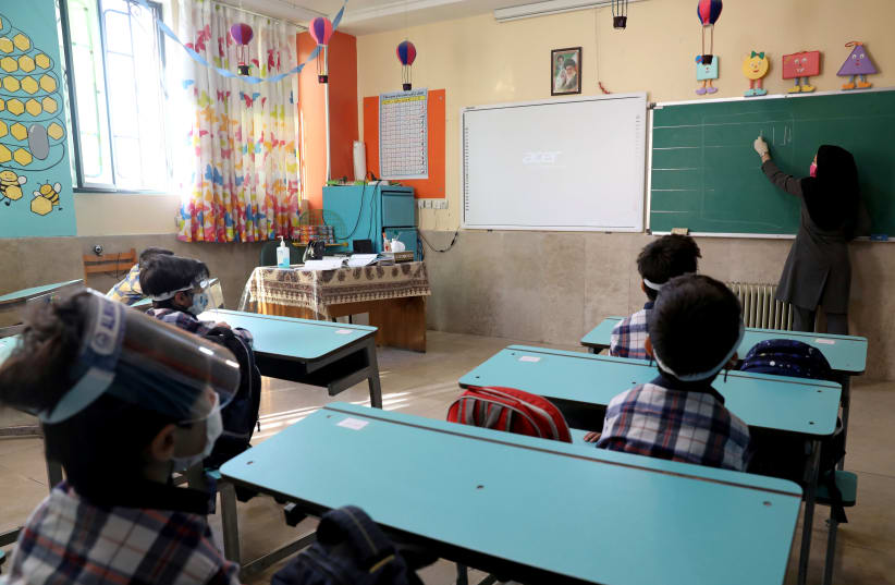  Students and their teacher wear protective gear to help prevent the spread of the coronavirus disease (COVID-19), in a classroom at Al-Mahdi School in Tehran (photo credit: MAJID ASGARIPOUR/WANA/REUTERS)