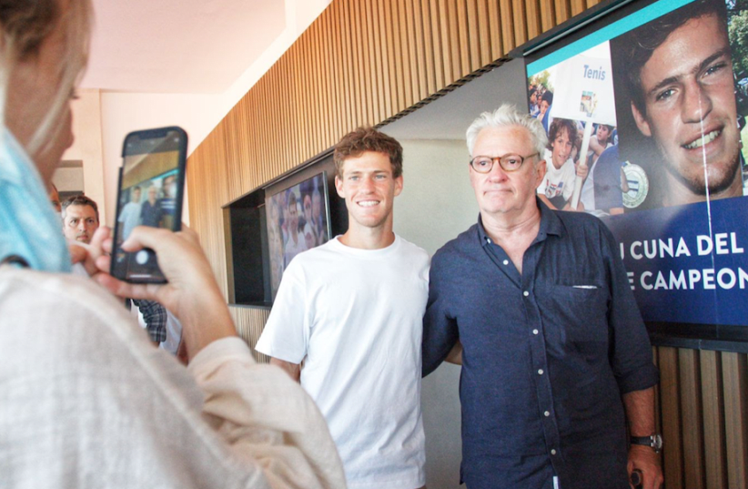  Diego Schwartzman and his father Ricardo pose for photos during the inauguration of a new tennis complex named in the tennis star's honor in Tigre, Argentina, Dec. 11, 2021. (photo credit: Courtesy Hacoaj/JTA)