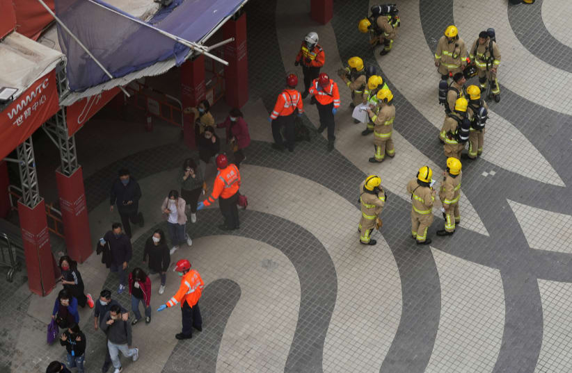  Rescue workers evacuate people from the site after a fire broke out at the World Trade centre in Hong Kong, China. (photo credit: REUTERS)