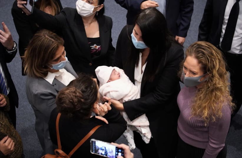  Yamina MK Shirly Pinto arrives at the Knesset plenum with her baby six days after giving birth, December 15, 2021. (photo credit: NOAM MOSKOVITZ/KNESSET)