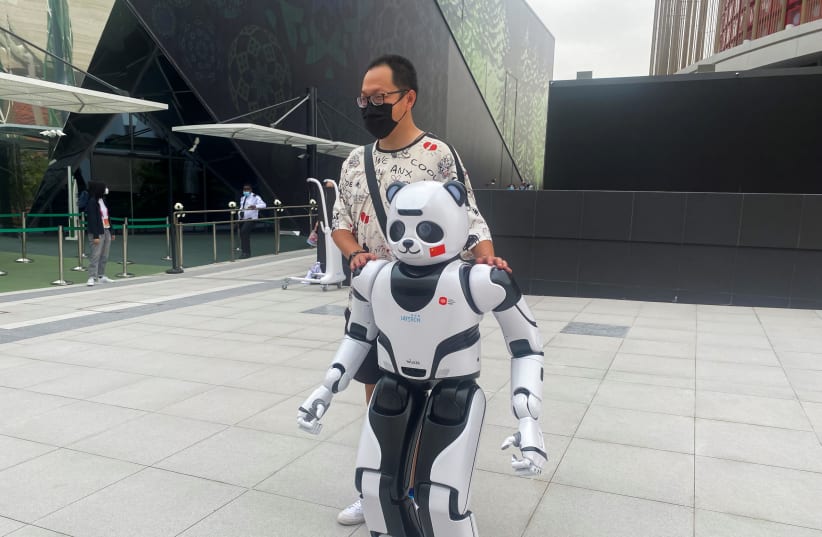  A man stands next to a panda robot at the Chinese Pavilion at the Expo 2020 in Dubai, United Arab Emirates, October 4, 2021 (photo credit: REUTERS/JACOB GREAVES)