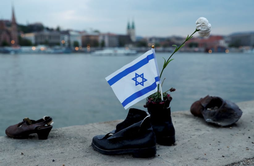 Israeli flag is seen attached to "Shoes on the Danube Bank" memorial during the annual "March of the Living" to commemorate victims of the Holocaust (photo credit: REUTERS/BERNADETT SZABO)