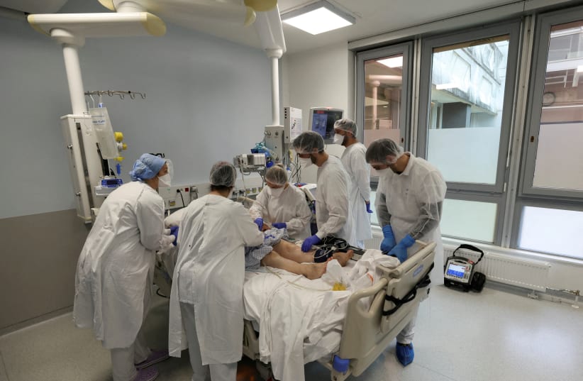  Medical personnel work at the Intensive Care Unit (ICU) for COVID-19 patients at the Emile Muller GHRMSA hospital in Mulhouse, France, December 16, 2021 (photo credit:  REUTERS/YVES HERMAN/FILE PHOTO)