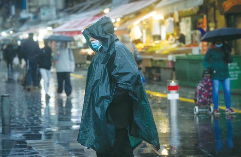  People walk in the rain on a Jerusalem street on Wednesday.  (photo credit: YONATAN SINDEL/FLASH90)