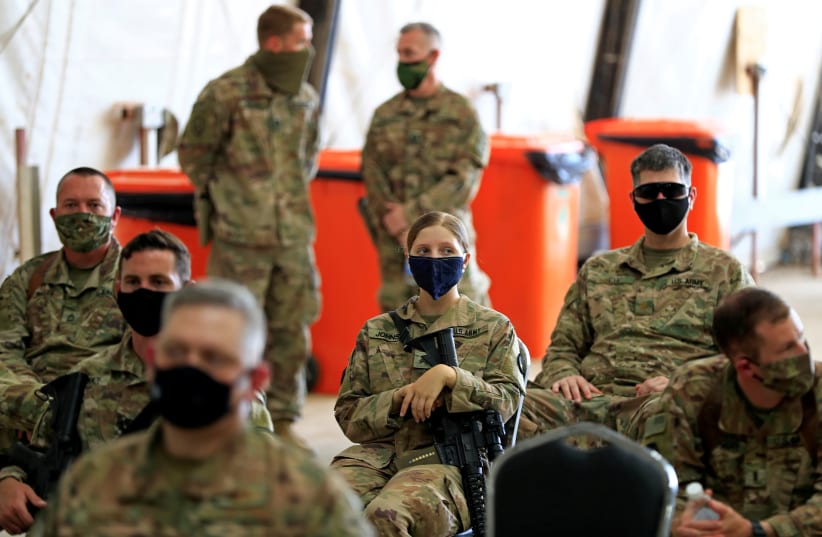 US soldiers wearing protective masks are seen during a handover ceremony of Taji military base from US-led coalition troops to Iraqi security forces, in the base north of Baghdad, Iraq August 23, 2020 (photo credit: REUTERS/THAIER AL-SUDANI)