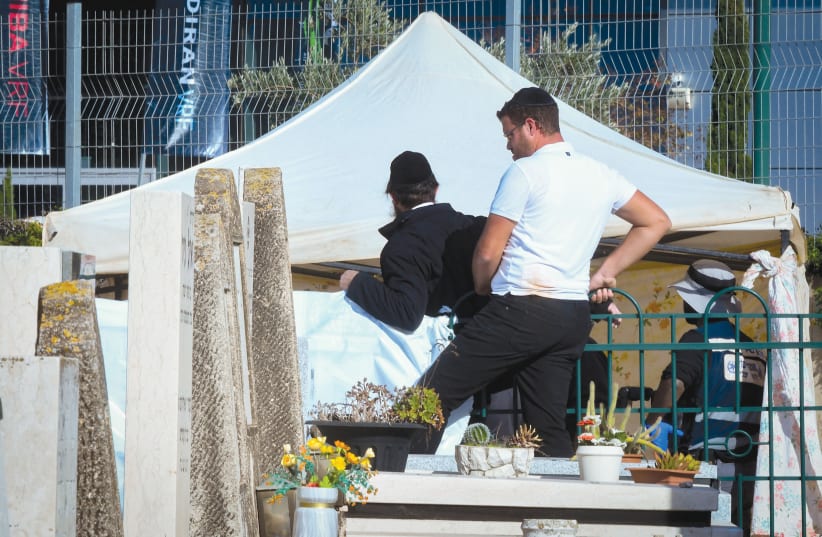  POLICE AND medical personnel at the scene where Chaim Walder was found dead near his son’s grave, in Petah Tikva, December 27.  (photo credit: FLASH90)