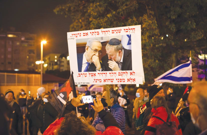  A PROTEST against a plea deal with former prime minister Benjamin Netanyahu takes place last Saturday night near the Petah Tikva home of Attorney-General Avichai Mandelblit. Netanyahu and Mandelblit are seen in the photo on the placard.  (photo credit: CHEN LEOPOLD/FLASH90)