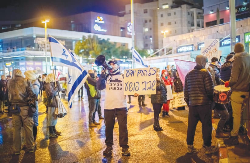  DEMONSTRATORS PROTEST against a plea deal with former prime minister Benjamin Netanyahu, near the home of Attorney-General Avichai Mandelblit, in Petah Tikva, on January 15. The poster, which rhymes in Hebrew, reads: ‘The whole country knows, Bibi is a criminal.’ (photo credit: CHEN LEOPOLD/FLASH90)