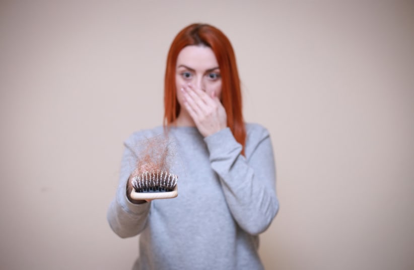  A woman's hair comes out after brushing. Is she balding? (Illustrative) (photo credit: MAXPIXEL)