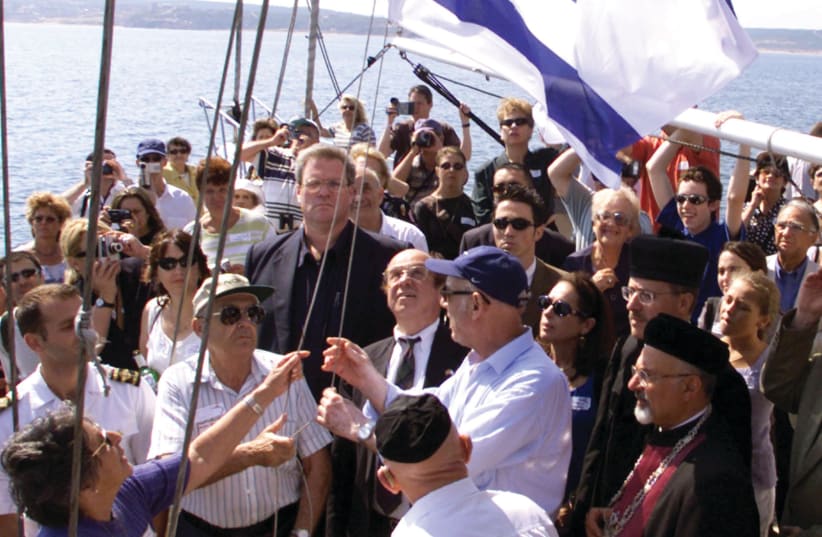  AN ISRAELI FLAG is raised by relatives of the ‘Struma’ victims during a memorial service off the coast of Istanbul in 2000 (photo credit: REUTERS)
