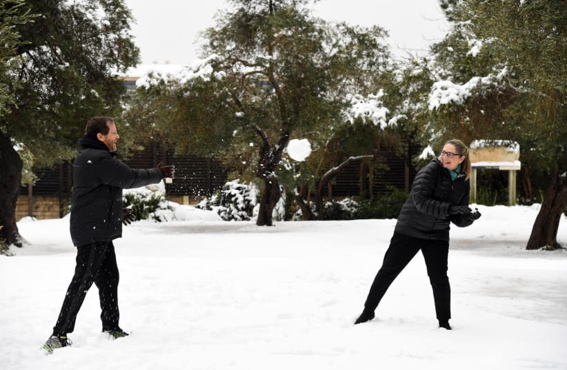  President Isaac Herzog and his wife Michal playing in the snow, January 27, 2022.  (photo credit:  ALON HACHMON/MAARIV)