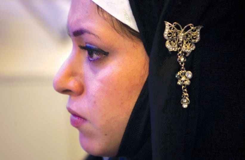  An Iranian woman wears jewelry on her hijab as she attends a ceremony to mark National Chastity and Hijab Day in Tehran. (photo credit: MORTEZA NIKOUBAZI/ REUTERS)