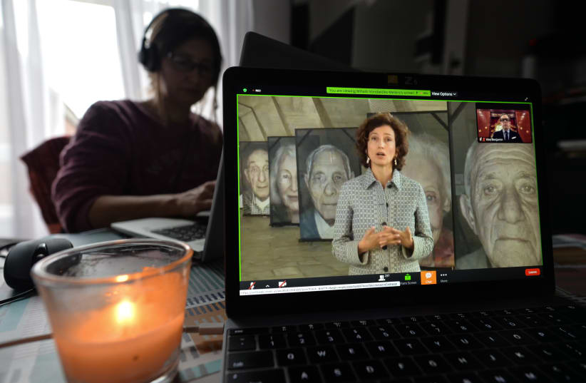  A woman watches Audrey Azoulay, UNESCO's director-general, speak during an online commemoration on International Holocaust Remembrance Day in Dublin, Jan. 27, 2021. (photo credit: ARTUR WIDAK/NURPHOTO VIA GETTY IMAGES)