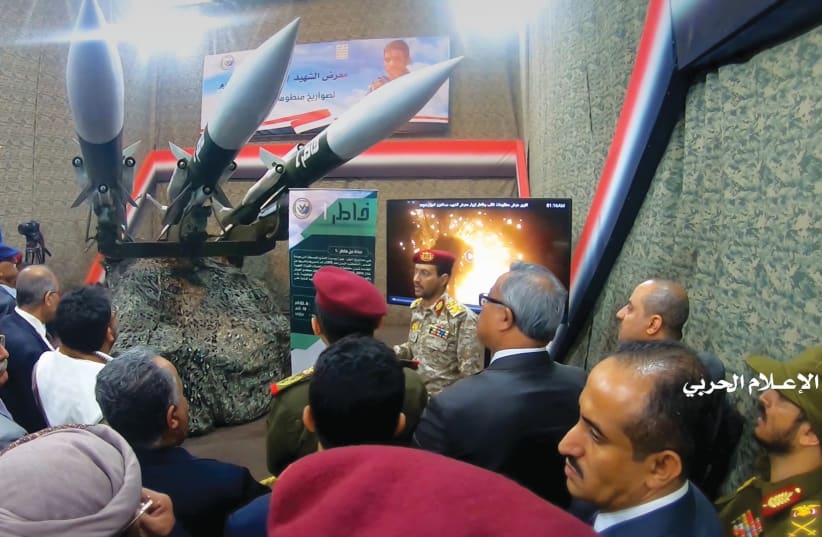  HOUTHI OFFICIALS gather around surface-to-air missiles on display, during an exhibition in an unidentified location in Yemen, in this undated photo released by the Houthi Media Office in Feb. 2020. (photo credit: HOUTHI MEDIA OFFICE/HANDOUT VIA REUTERS)