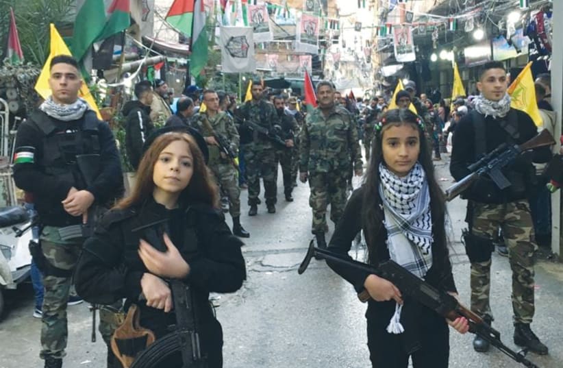  GIRLS WITH automatic rifles lead Fatah’s anniversary parade as seen, according to Palestinian Media Watch, on the official Fatah Facebook page. (photo credit: PALESTINIAN MEDIA WATCH)