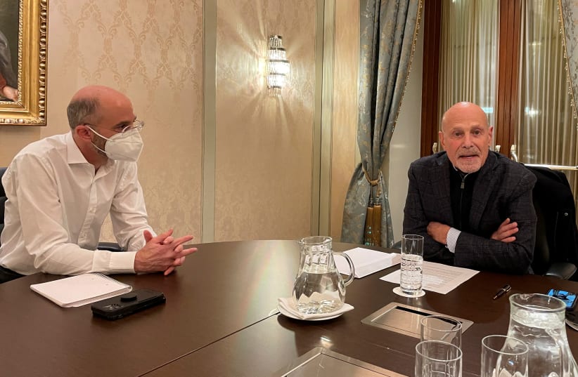  US Special Envoy for Iran Robert Malley and Barry Rosen, campaigning for the release of hostages imprisoned by Iran, sit at a table during an interview with Reuters in Vienna, Austria. (photo credit: REUTERS/FRANCOIS MURPHY)