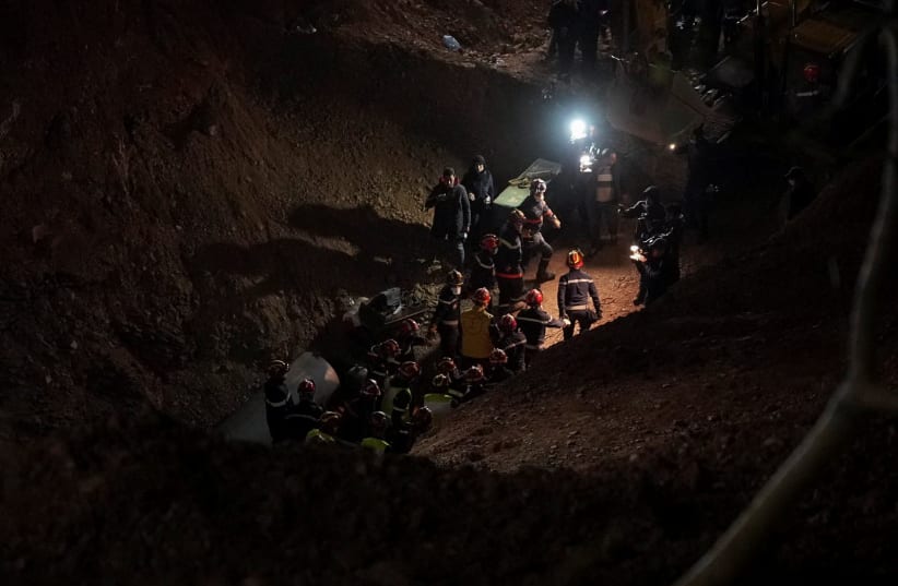 Rescue workers carry 5-year-old child, Rayan Awram, who has been trapped for five days in a well, to an ambulance, during a rescue operation near Chefchaouen, northern Morocco, February 5, 2022. (photo credit: REUTERS/THAMI NOUAS)