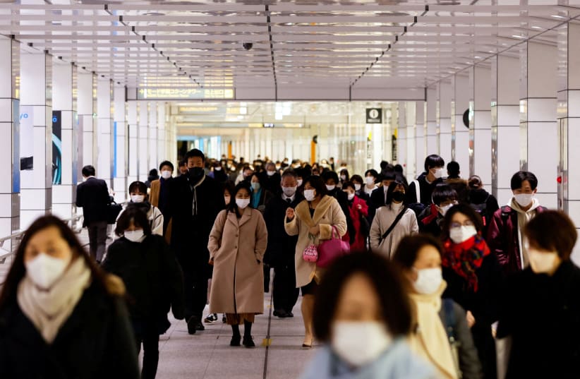  Passersby wearing protective face masks walk at a train station concourse, amid the coronavirus disease (COVID-19) pandemic, in Tokyo, Japan, February 9, 2022.  (photo credit: REUTERS/ISSEI KATO)