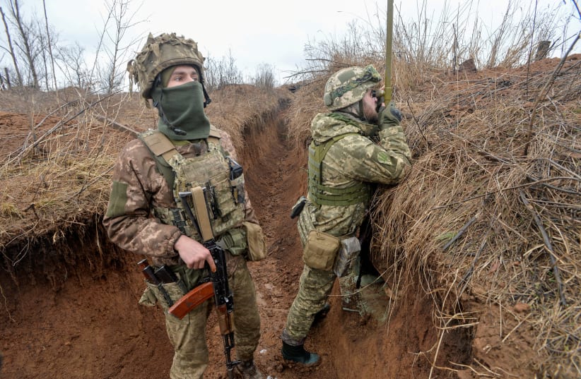  Service members of the Ukrainian armed forces stand guard at combat positions near the line of separation from Russian-backed rebels in the town of New York in the Donetsk region, Ukraine February 9, 2022. (photo credit: REUTERS/OLEKSANDR KLYMENKO)