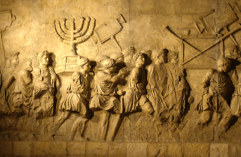  The menorah from the Second Temple is depicted being carried by Romans on the Arch of Titus. (photo credit: AMOS BEN GERSHOM/GPO)