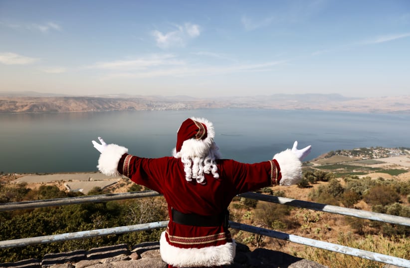  Issa Kassissieh, wearing a Santa Claus costume, stands at a lookout point at the Sea of Galilee, as Israel geared up for the 2021 Christmas holiday season. (photo credit: RONEN ZVULUN/REUTERS)
