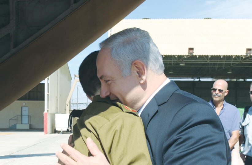  FREED SOLDIER Gilad Schalit is greeted by then-prime minister Benjamin Netanyahu at Tel Nof Airbase on October 18, 2011. (photo credit: GPO via Getty Images)