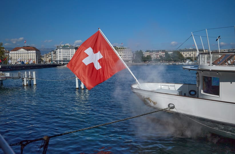  A Swiss flag is pictured at the harbour in Geneva, Switzerland, September 24, 2021. (photo credit: REUTERS/DENIS BALIBOUSE)