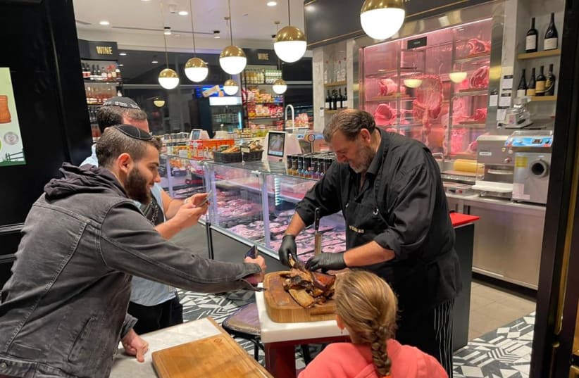  Marco Abutbul,  butcher and chef with more than fifty years of experience, serves a delectable gourmet dish to customers (photo credit: Courtesy)