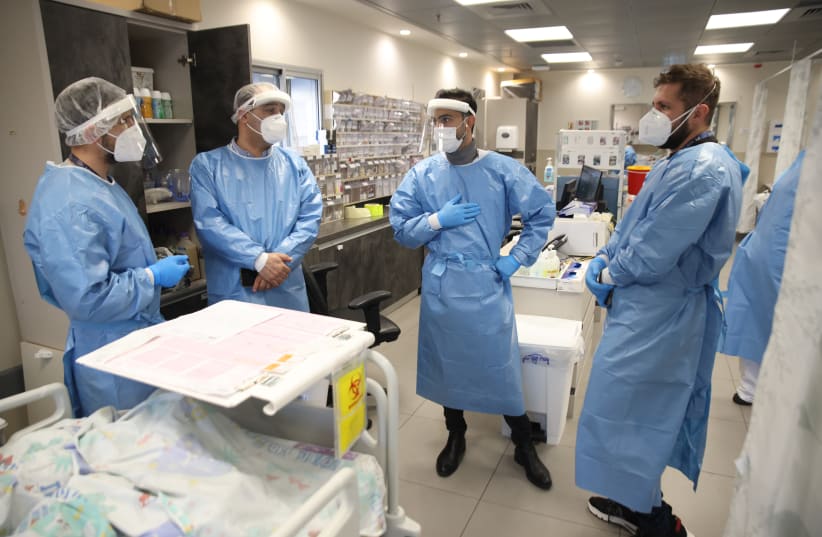  Ziv hospital team members wearing safety gear as they work in the Coronavirus ward of Ziv Medical Center in the northern Israeli city of Tzfat on February 15, 2022.  (photo credit: DAVID COHEN/FLASH 90)
