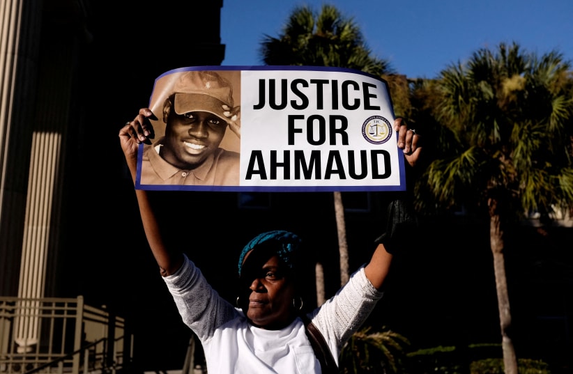  A woman holds a sign outside the Glynn County Courthouse after the jury reached a guilty verdict in the trial of William "Roddie" Bryan, Travis McMichael and Gregory McMichael, charged with the February 2020 death of 25-year-old Ahmaud Arbery, in Brunswick, Georgia, US, November 24, 2021 (photo credit: MARCO BELLO/REUTERS)