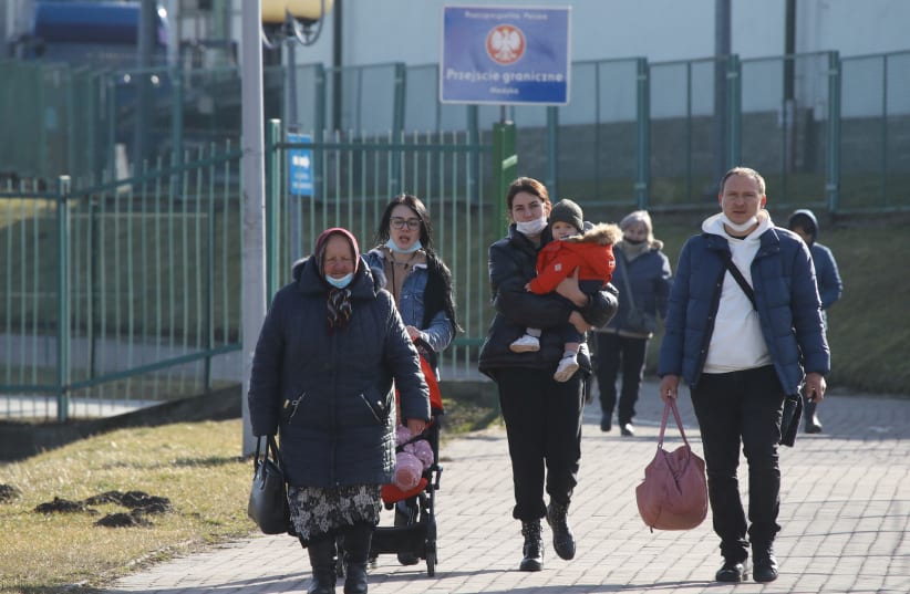  People walk at the border crossing between Poland and Ukraine, after Russian President Vladimir Putin authorized a military operation in eastern Ukraine, in Medyka, Poland, February 24, 2022.  (photo credit: KACPER PEMPEL/REUTERS)