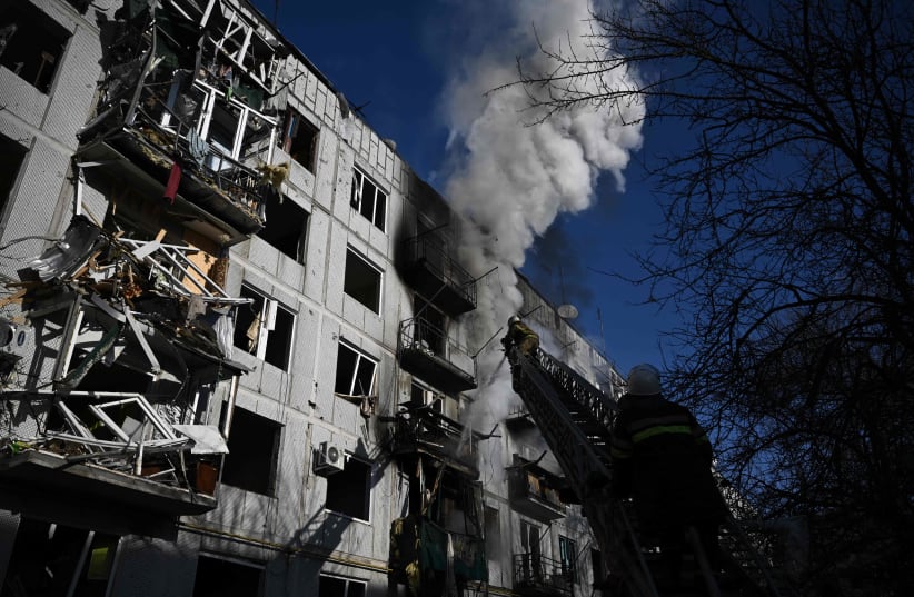  Firefighters work on a fire on a building after bombings on the eastern Ukraine town of Chuguiv on February 24, 2022 (photo credit: ARIS MESSINIS/AFP via Getty Images)