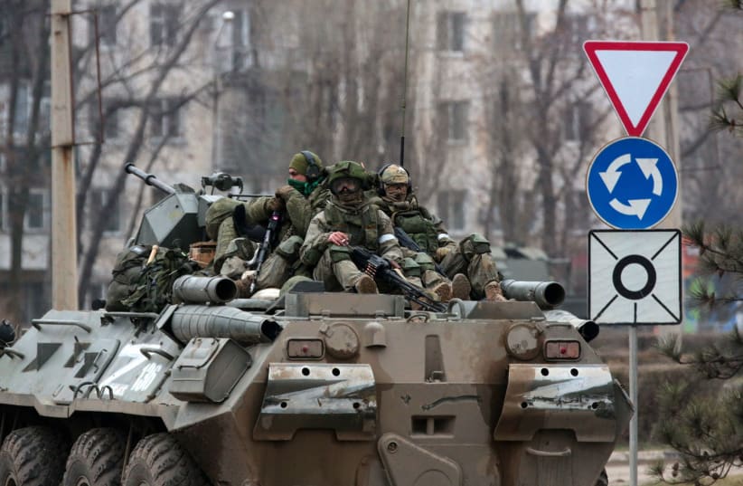  Servicemen ride atop a Russian armored vehicle in Armyansk, Crimea, on February 25, 2022 (photo credit: STRINGER/AFP VIA GETTY IMAGES)