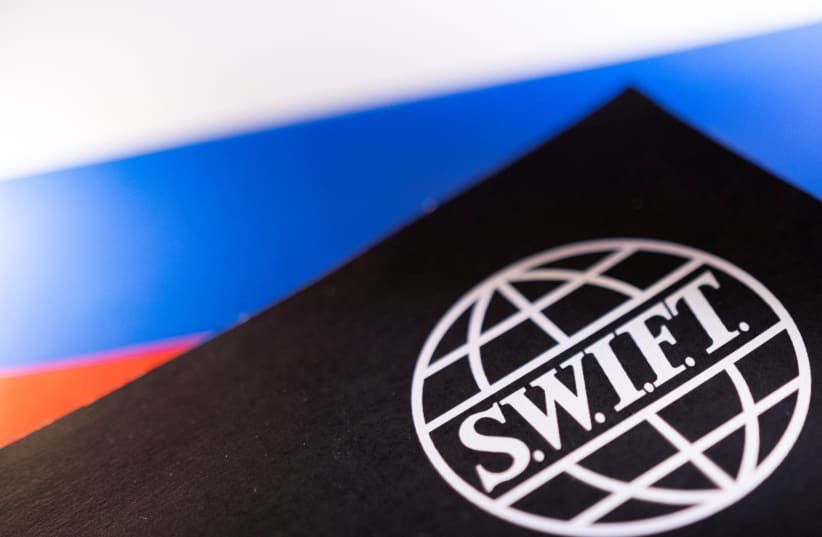 Swift logo is placed on a Russian flag are seen in this illustration taken, Bosnia and Herzegovina, February 25, 2022. (photo credit: REUTERS/DADO RUVIC/ILLUSTRATION)