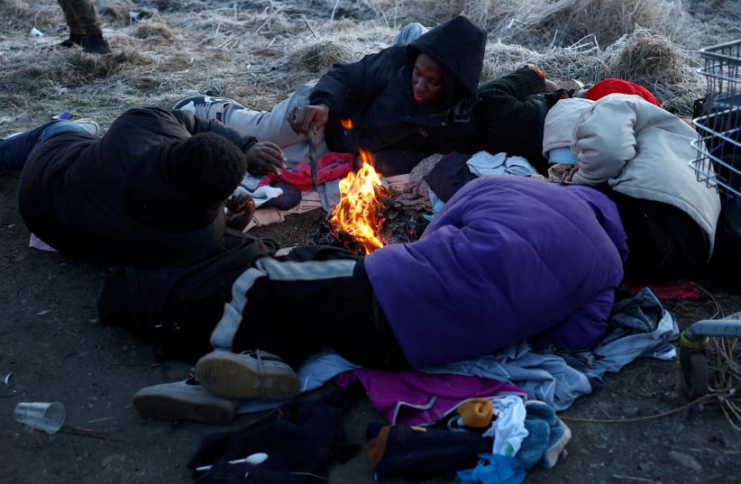  Refugees brave the cold in a frozen field after they fled from Ukraine because of the Russian invasion at the border checkpoint in Medyka, Poland, March 1, 2022. (photo credit: REUTERS/KAI PFAFFENBACH)