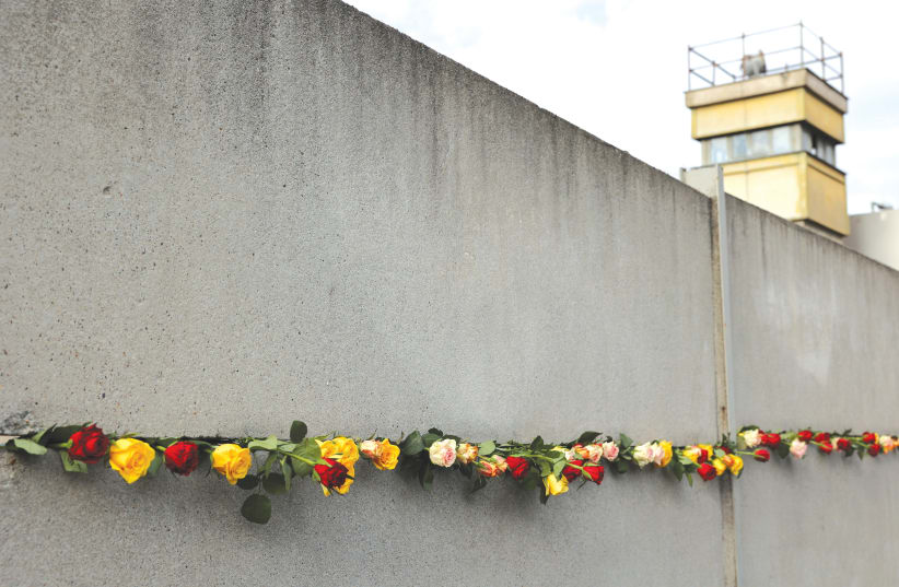  ROSES ARE placed at the Berlin Wall Memorial during a ceremony marking the 32nd anniversary of the fall of the wall, at Bernauer Strasse in Berlin on November 9, 2021. (photo credit: Christian Mang/Reuters)